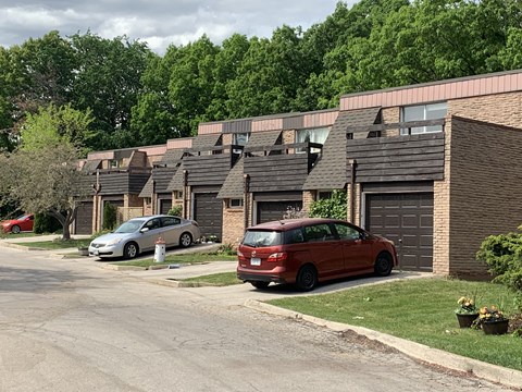 a row of houses with cars parked in front of them